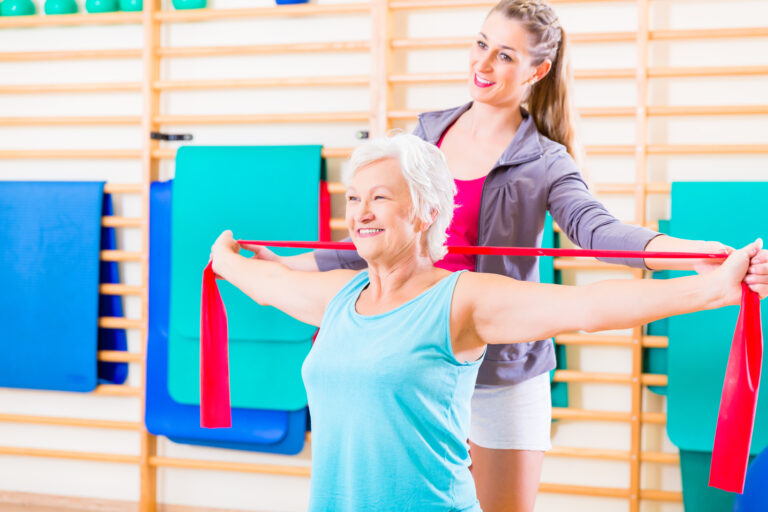 Senior woman with stretch band at fitness